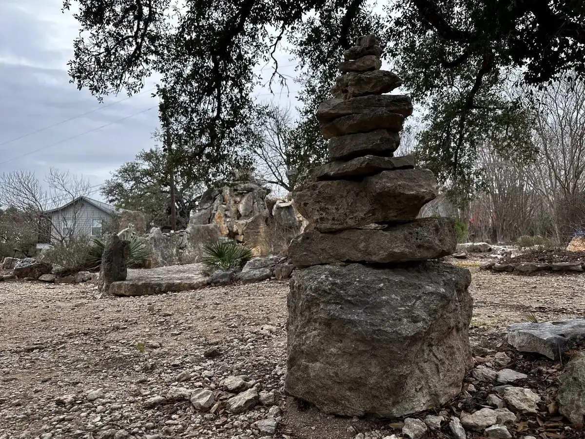 Stacked stone cairn beneath live oaks on the Nova Recovery Center grounds.