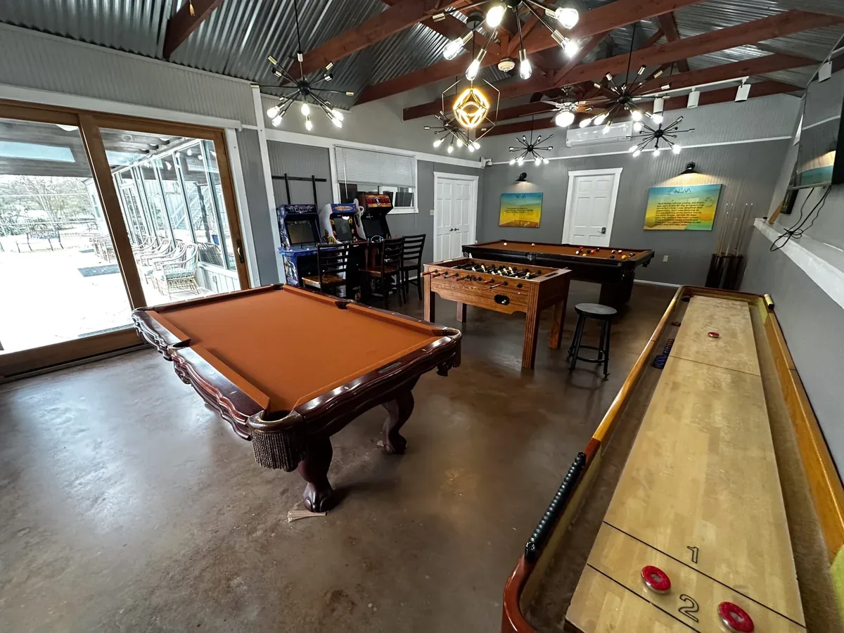 Recreation lounge with pool tables, arcade games, foosball, and shuffleboard at Nova Recovery Center.