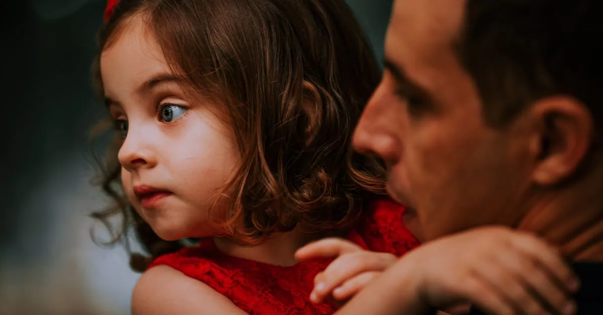 Heartfelt moment between father and daughter captured in a candid close-up embrace, highlighting connection.