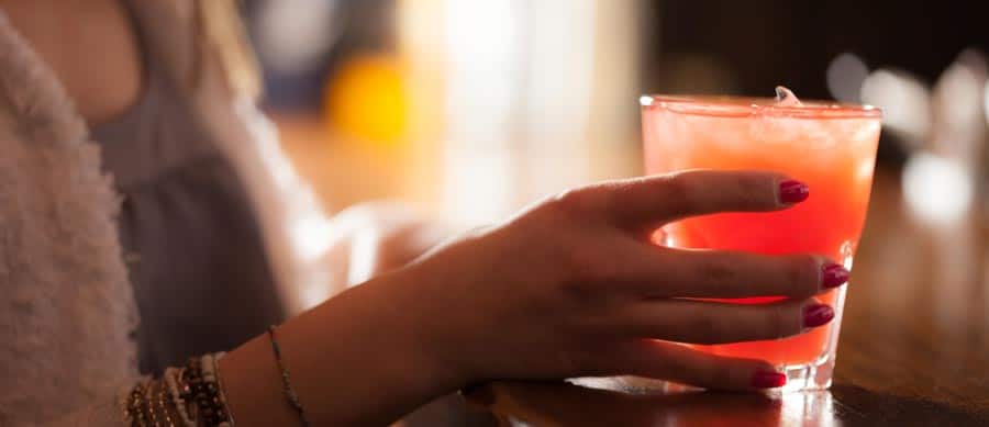 GHB Abuse Is Emerging Again in the Nightlife Scene woman having drink at nightclub