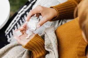 woman pouring prescription pills out of a bottle