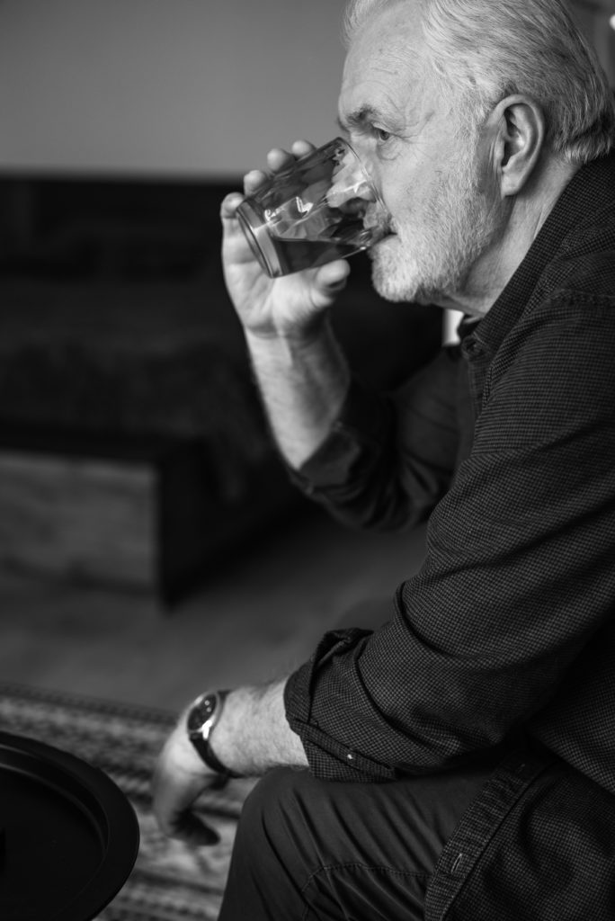 Older man drinking alone.