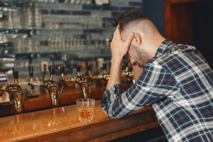 Lonely man drinking after addiction transference.