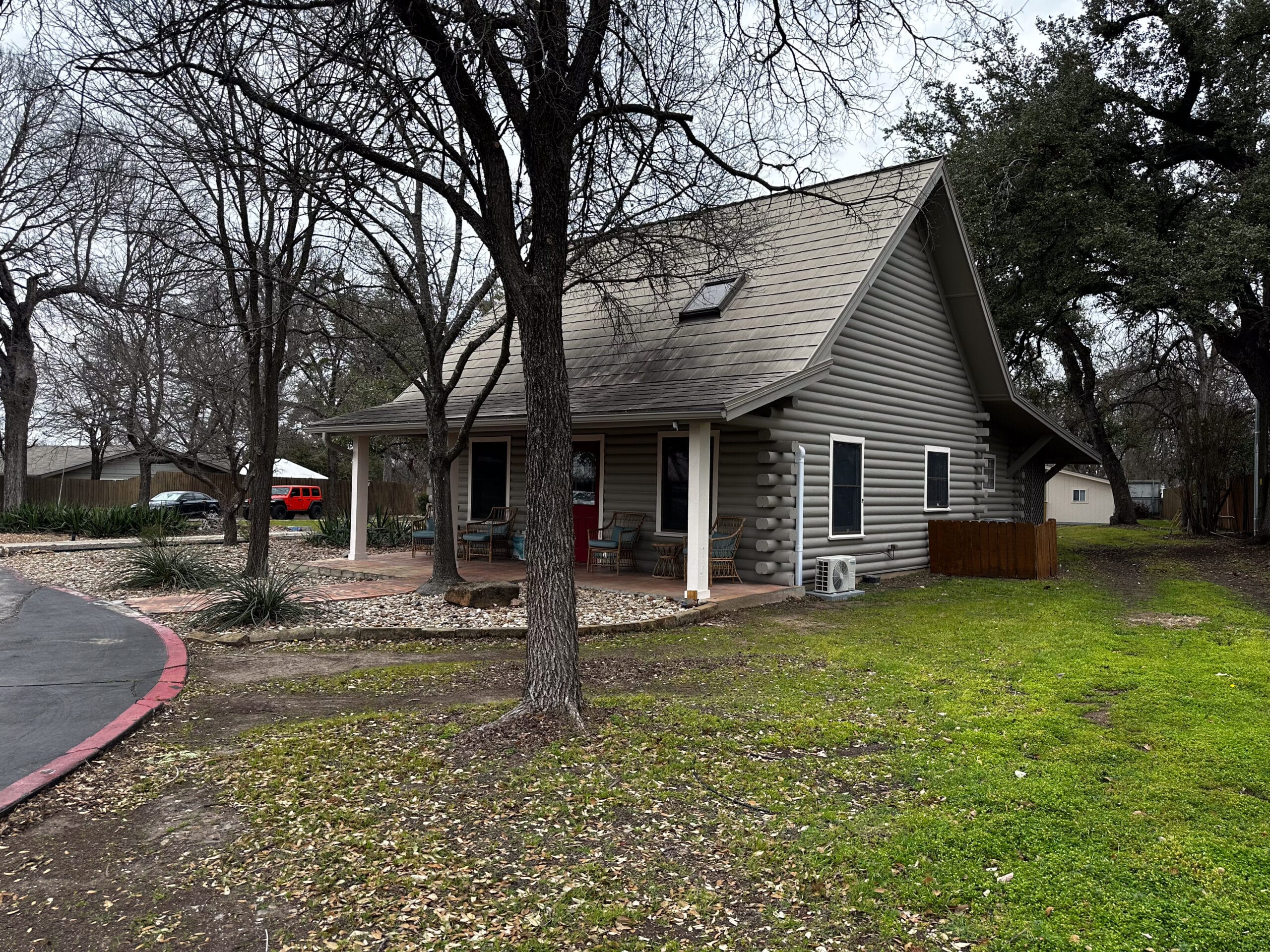 Exterior side view of Briarwood Detox Center Austin log cabin building surrounded by trees.