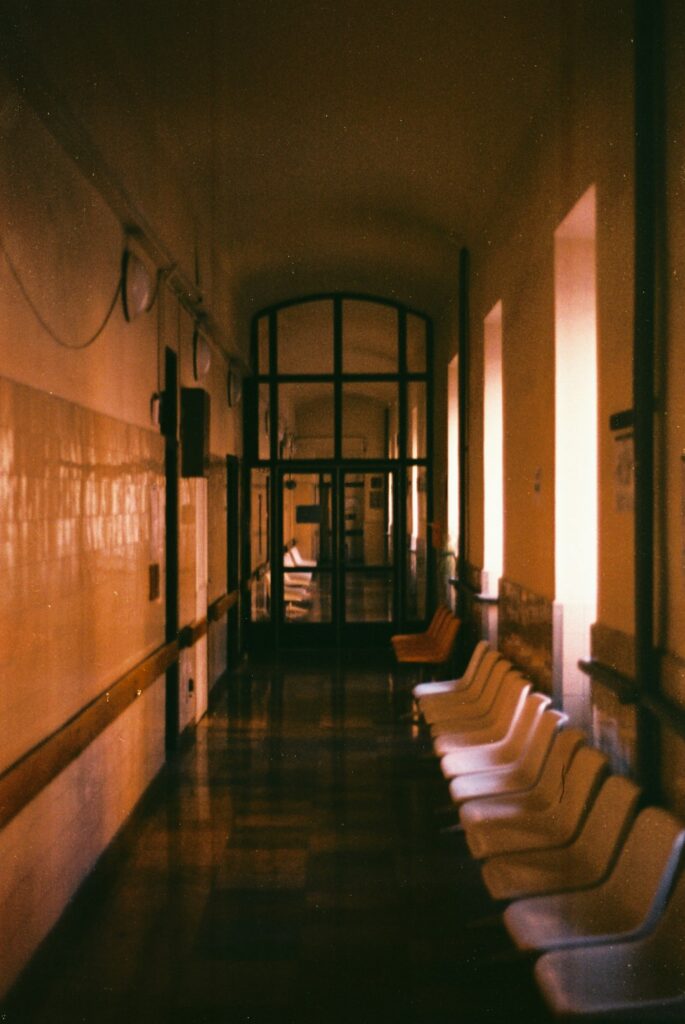 Empty hospital hallway with rows of chairs -- Photo by Szabolcs Antal on Unsplash