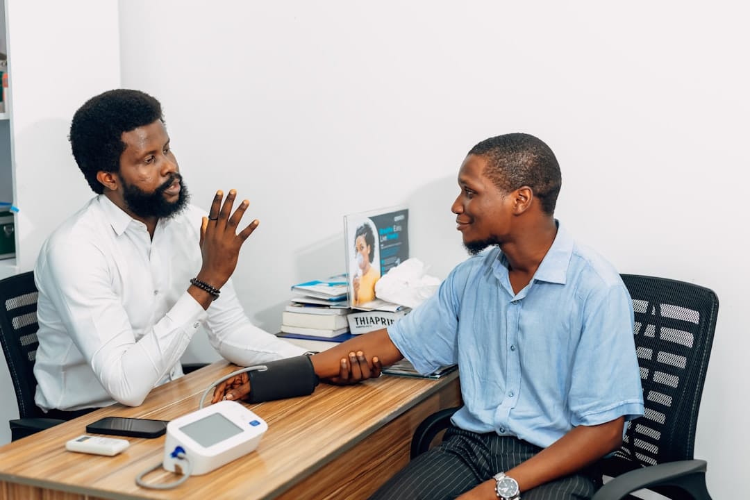 Two men sitting at a desk talking to each other -- Photo by Ninthgrid on Unsplash