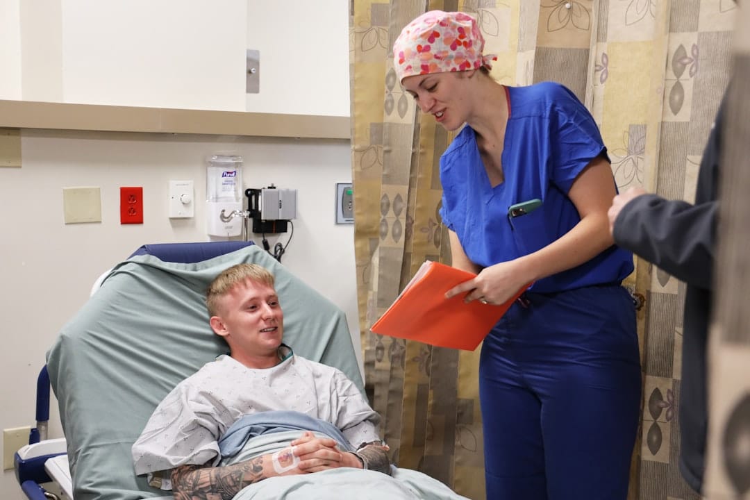 Nurse talking to patient in hospital bed. -- Photo by Navy Medicine on Unsplash