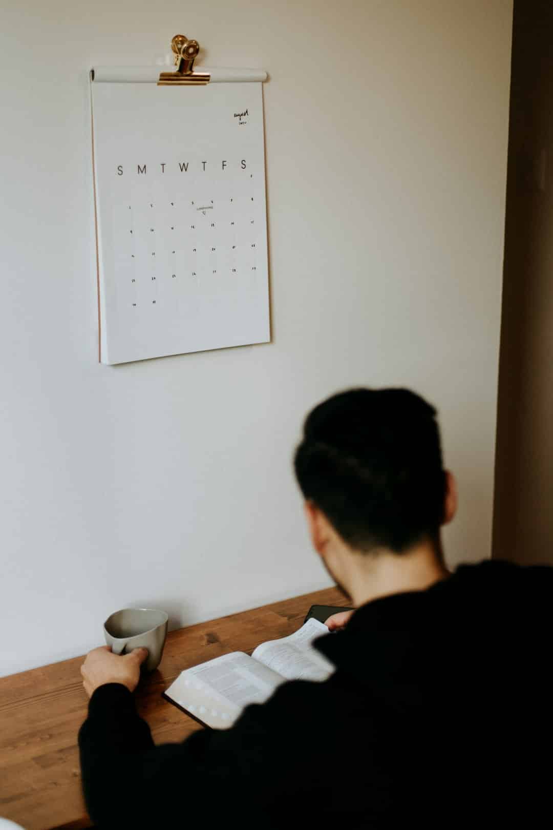 man in black shirt sitting beside brown wooden table -- Photo by Priscilla Du Preez 🇨🇦 on Unsplash