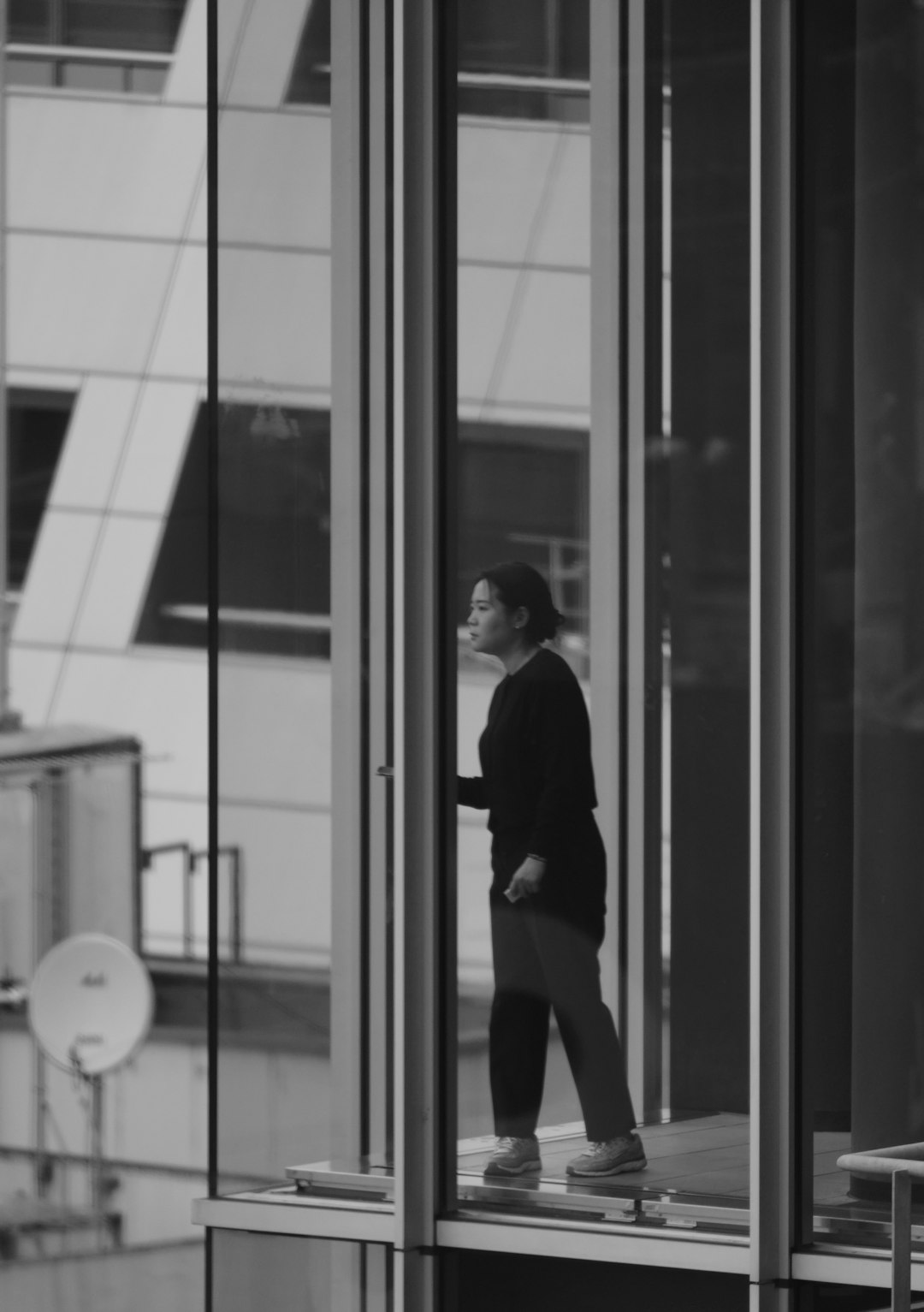 Woman looking out of a modern building window -- Photo by Haewon Oh on Unsplash