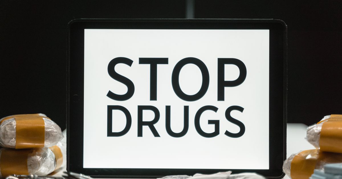 Tablet screen displaying anti-drug message surrounded by packaged substances, promoting awareness.