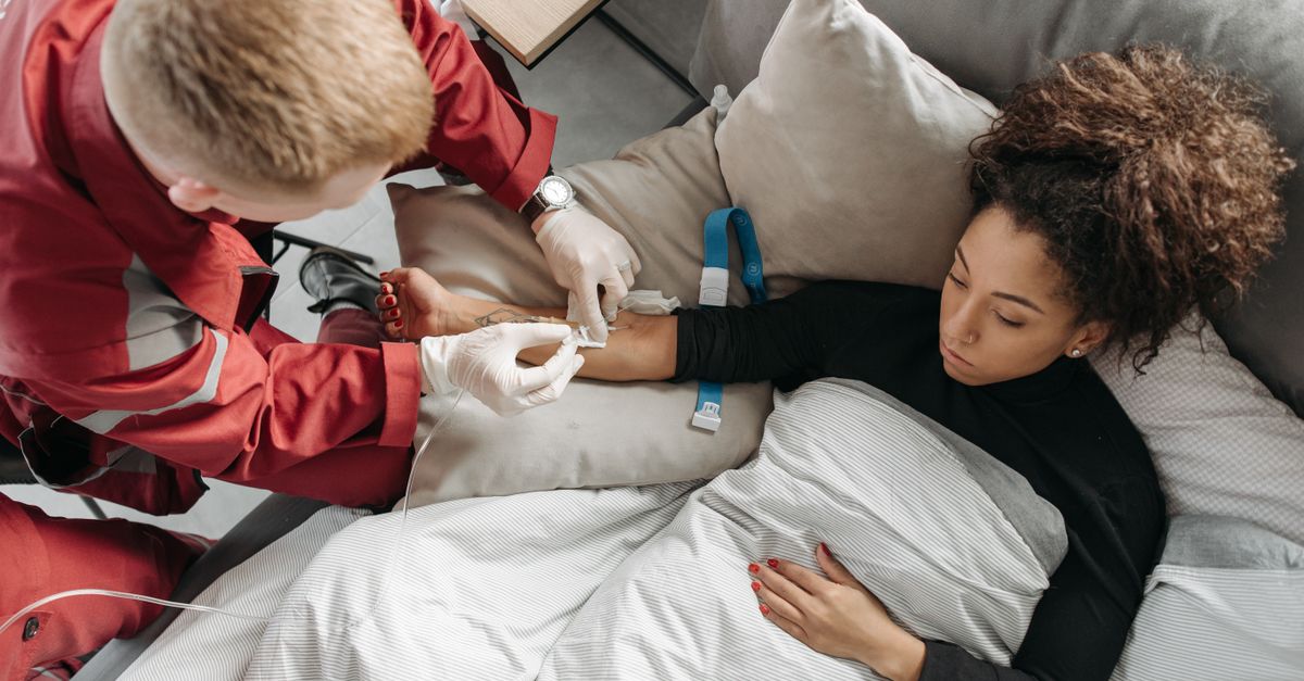 Paramedic tending to a woman at home, showcasing medical assistance in a personal setting.