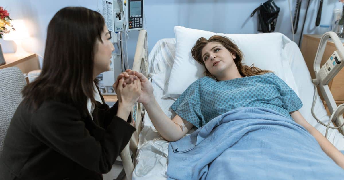 A comforting hospital visit with a patient receiving support from a friend.