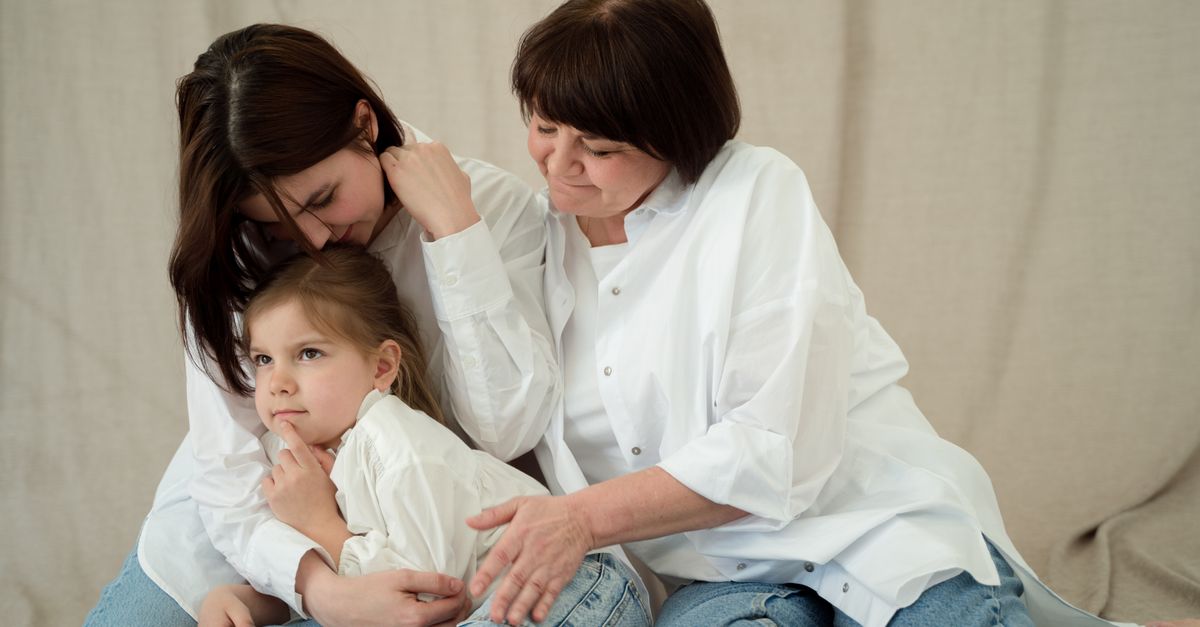 Heartwarming scene of three generations bonding in cozy jeans and white shirts, showcasing family love.