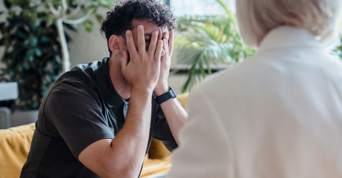 Man seeking support in therapy, expressing emotions during an indoor counseling session.