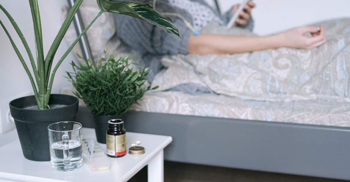 A patient resting in a hospital bed with care essentials nearby, illustrating a calm recovery environment.